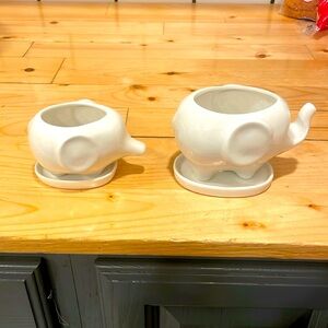 Two ceramic elephant planters with trays.